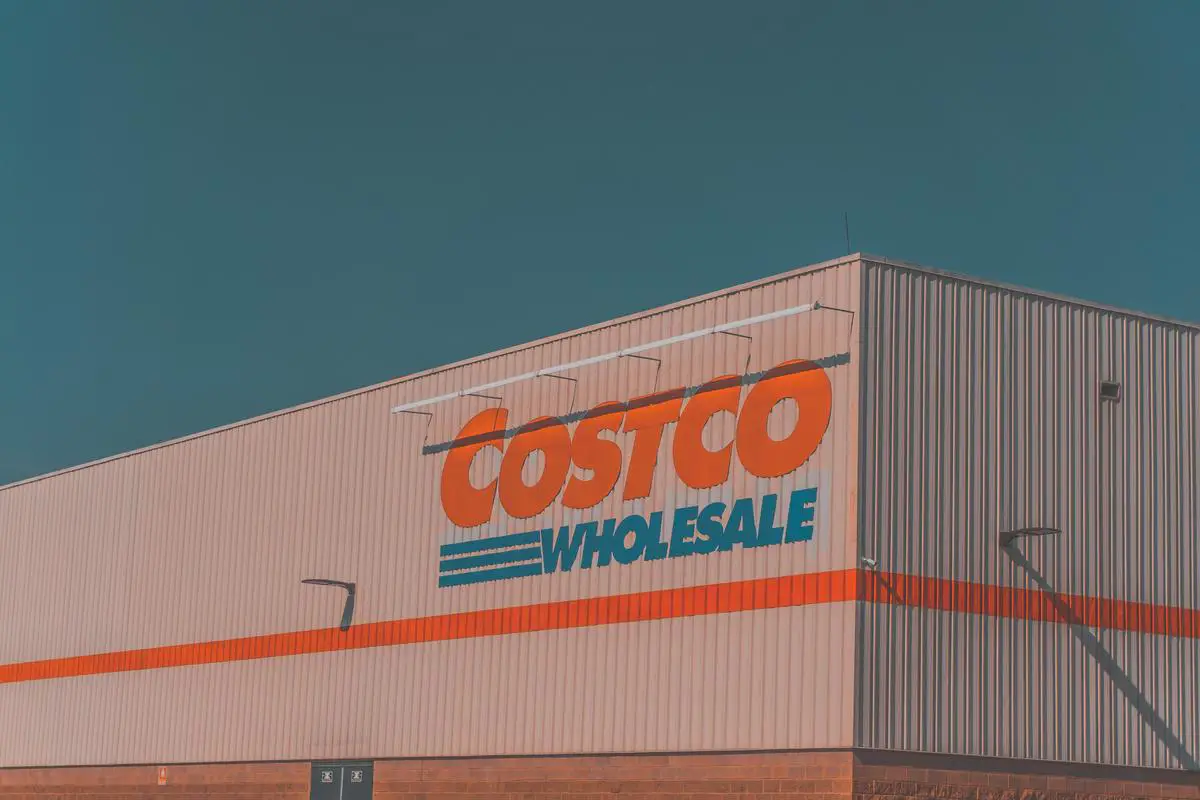 A picture of a Costco store with people shopping and browsing merchandise.