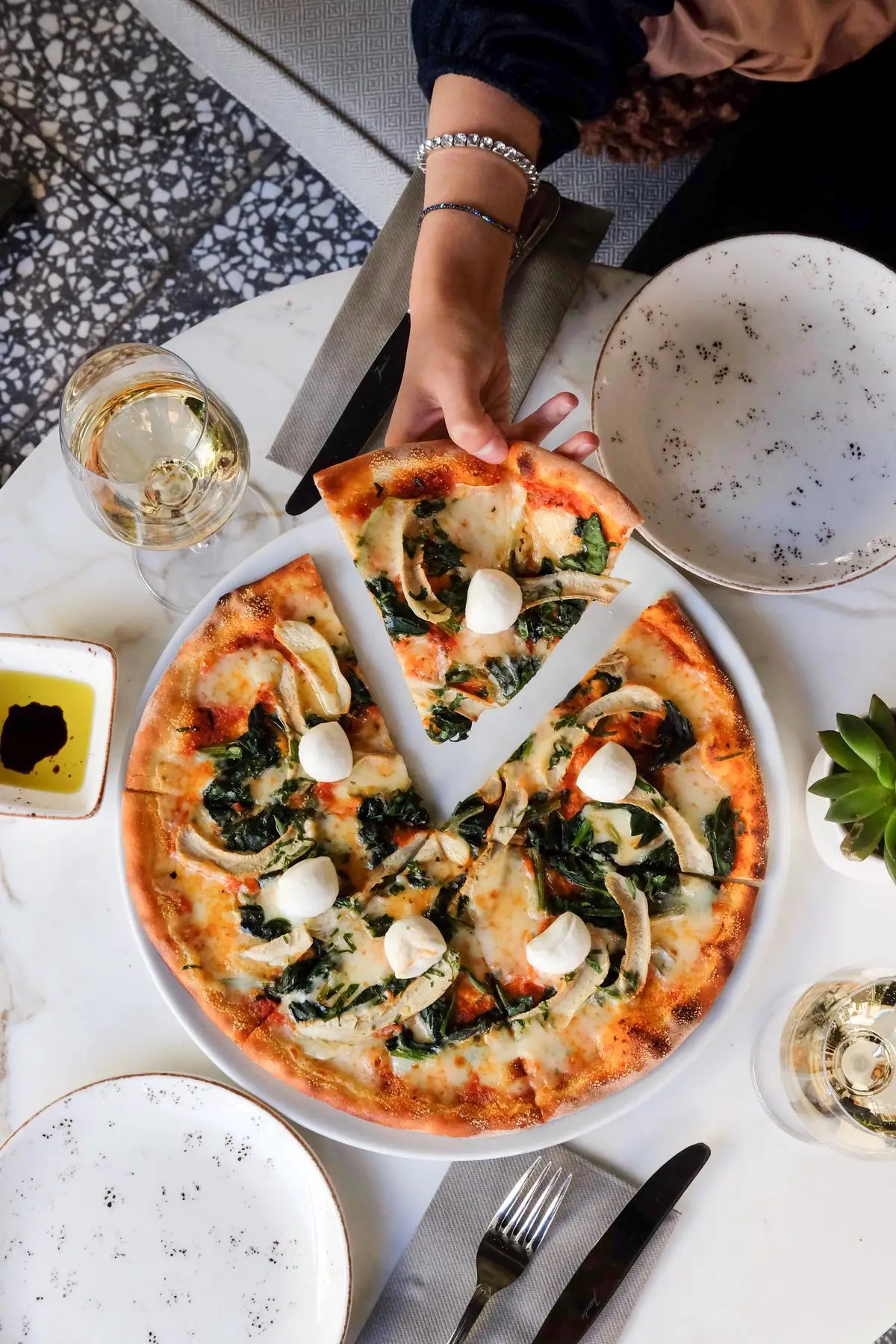 A delicious-looking gluten-free pizza topped with fresh vegetables and gooey cheese, ready to be enjoyed by a family at the dinner table.