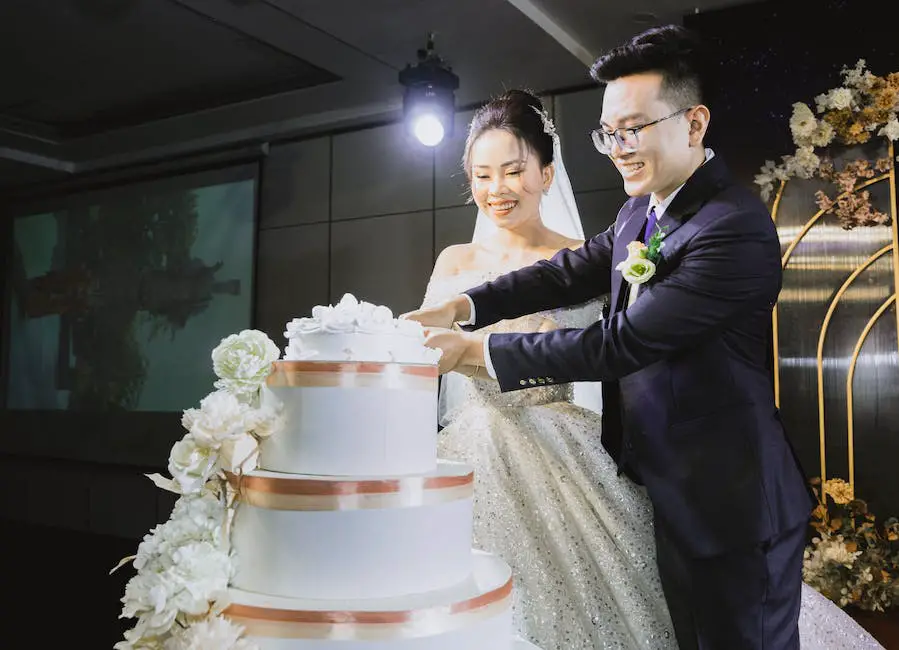 A couple cutting a cake at a wedding reception, showcasing the option of choosing a Costco wedding cake for affordability and flavor.