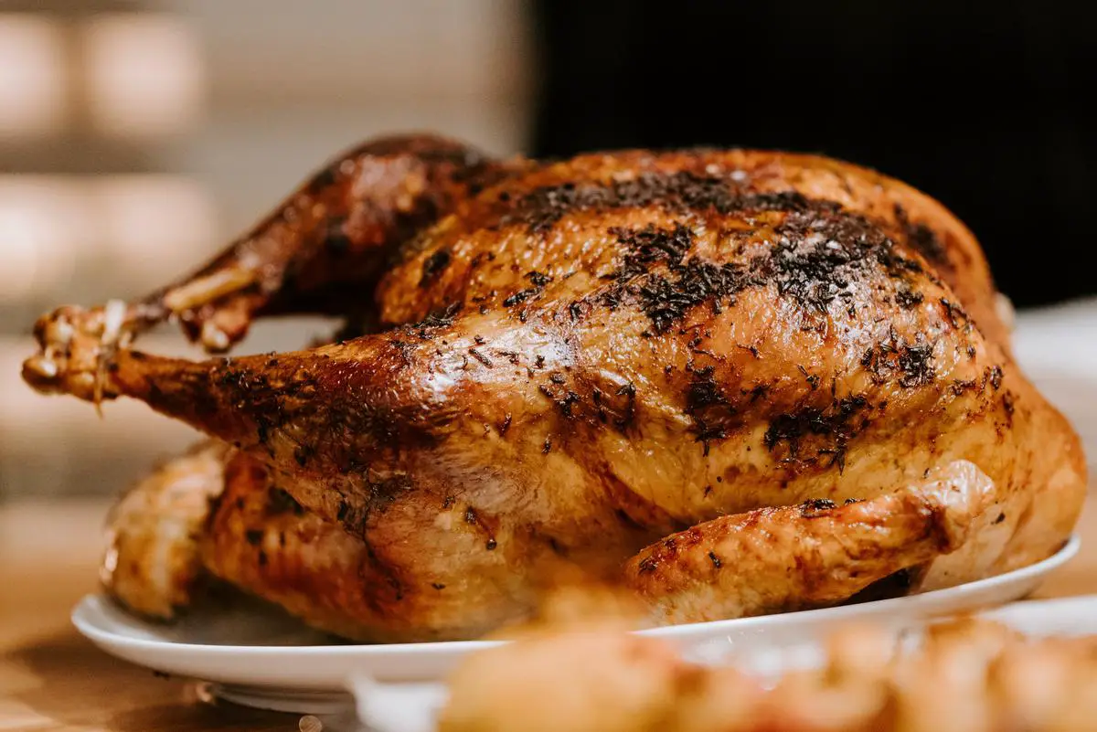 A roasted chicken on a plate, representing Costco's rotisserie chicken, a staple in many households.