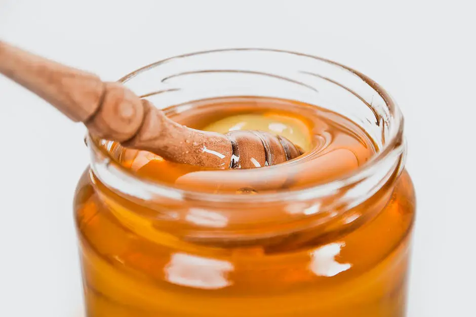 A jar of Manuka honey with a wooden dipper surrounded by fresh Manuka flowers.