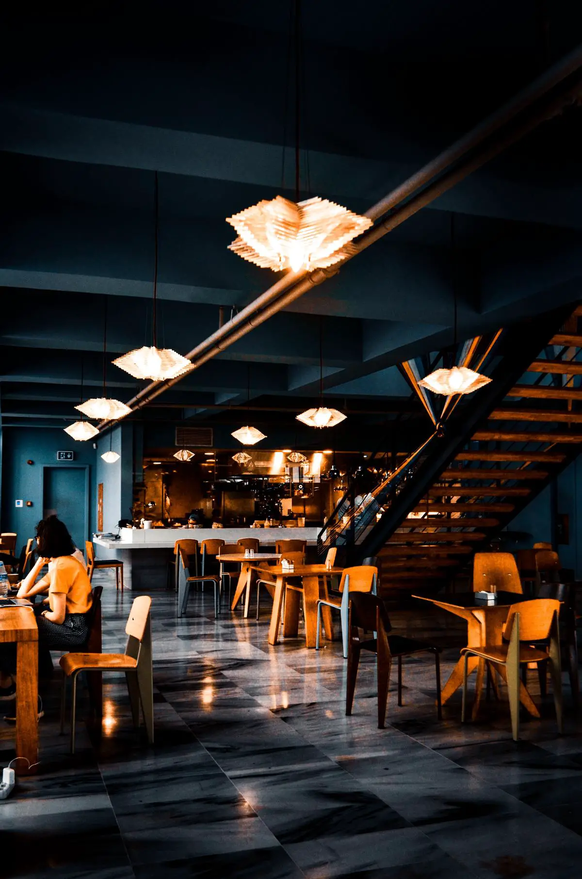 The image shows a spacious and well-lit restaurant with tables and chairs. It has a modern and welcoming interior design.