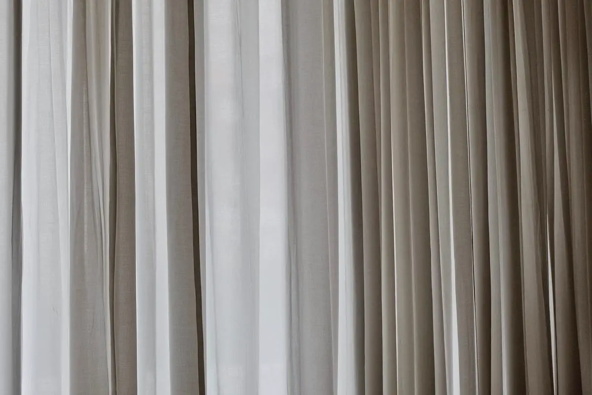 Image of IKEA blackout curtains hanging on a window, providing darkness and insulation.